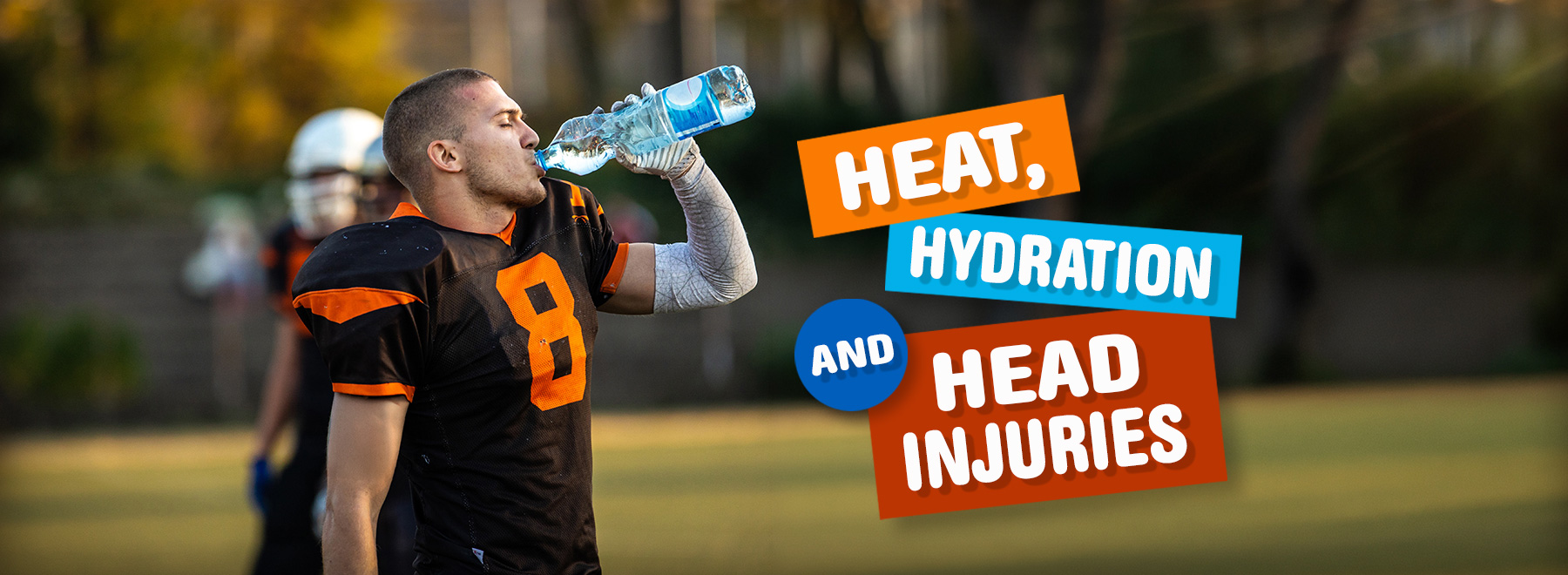 A football player wearing an orange jersey takes a drink from a water bottle, illustrating the significance of hydration in sports.